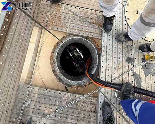 Tank cleaning robot removing sludge from an industrial tank