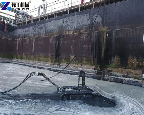 Remote-controlled robot removing sludge from a wastewater treatment tank